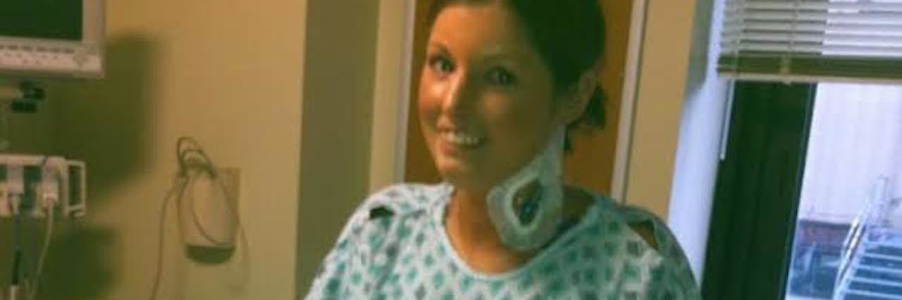 Facing the Reality of Permanent Disability With Scleroderma woman smiling in a hospital gown with an IV in her neck