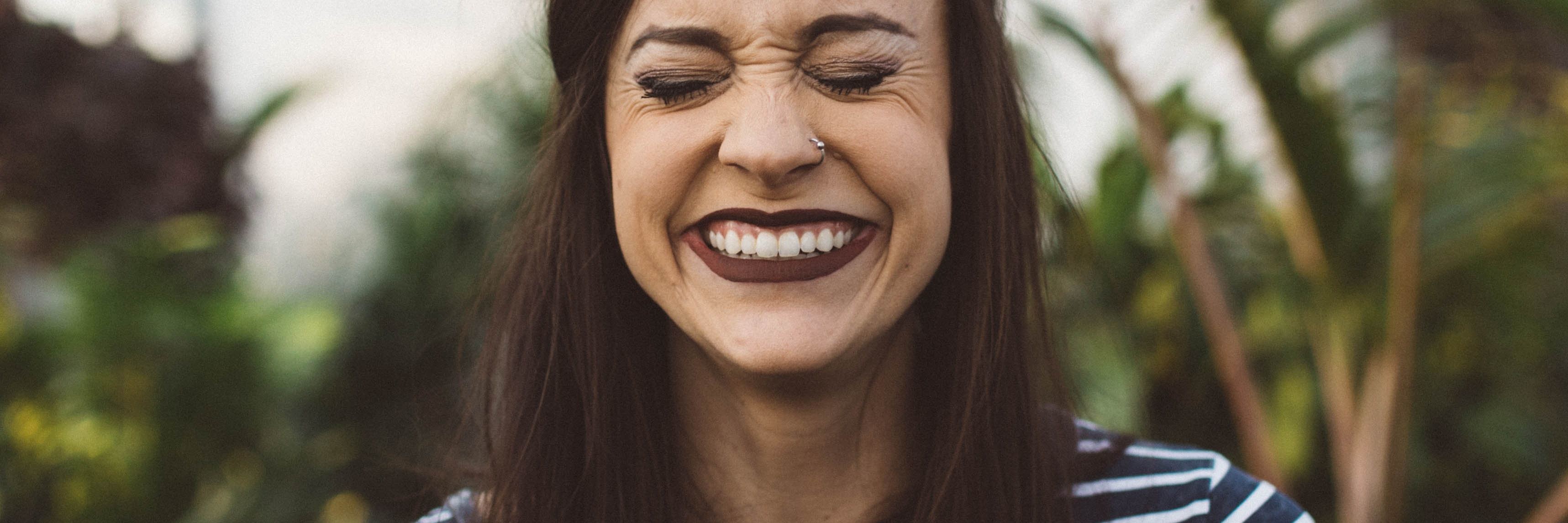 Why Your Time on a Psych Ward May Be Filled with Laughter woman wearing striped top in greenhouse laughing