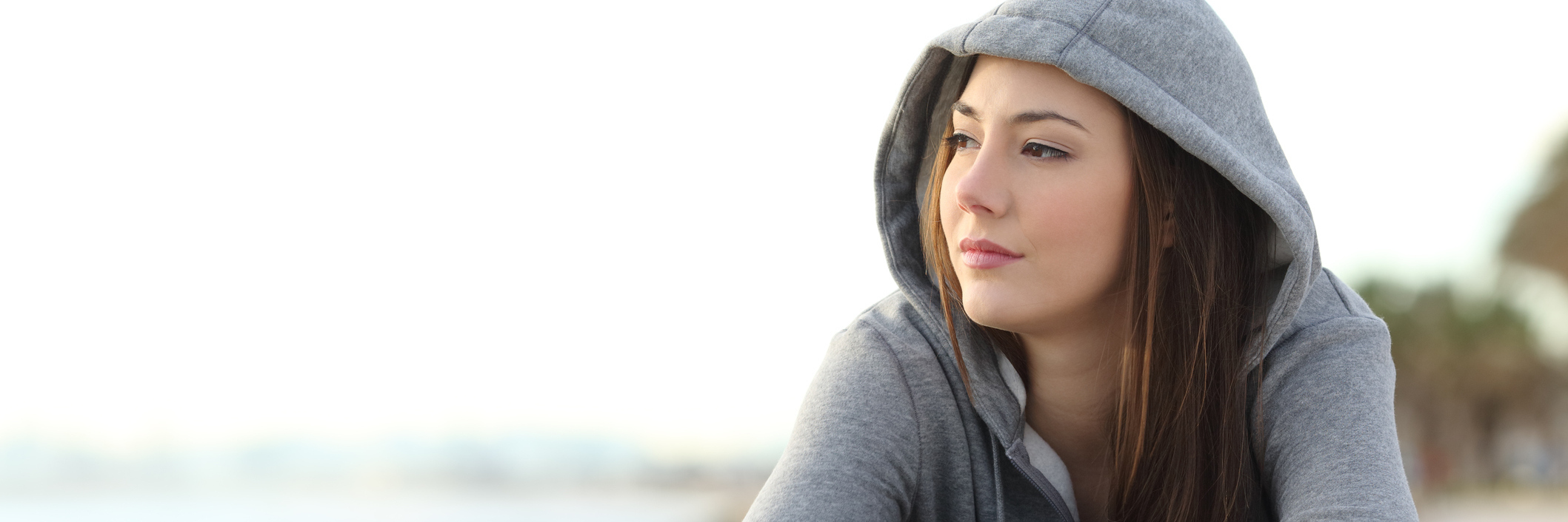 Close up of woman wearing a gray hoodie looking pensive