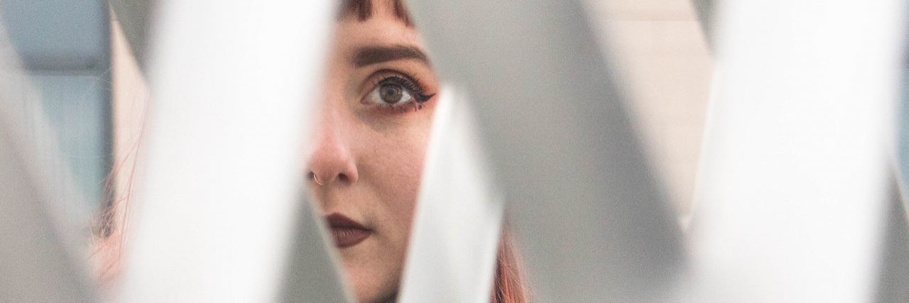 What I Wish I Could Tell People Who Stereotype OCD A woman looking through a fence