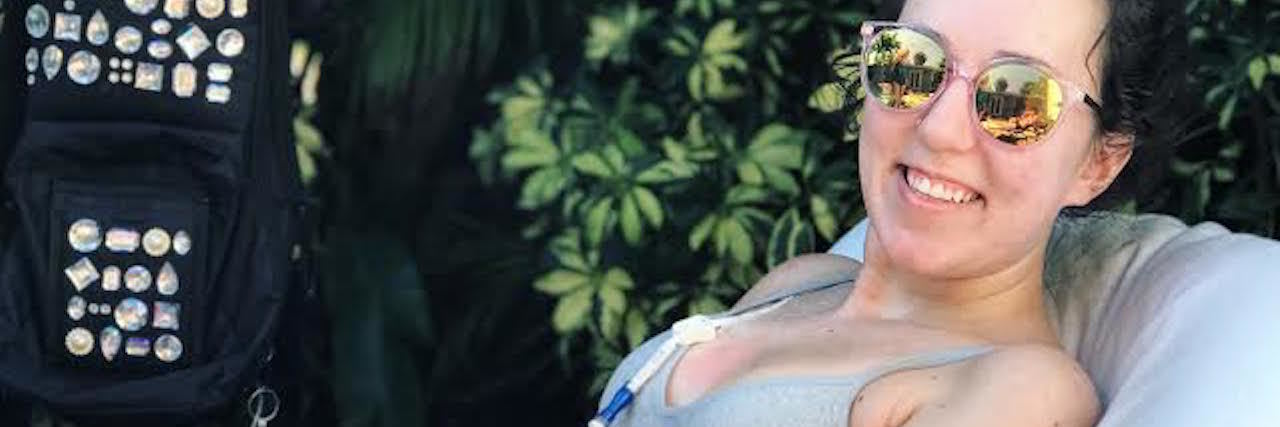 Thanking Body for Fighting Through Chronic Illness woman lying on a chair outside in a bathing suit with a feeding tube visible