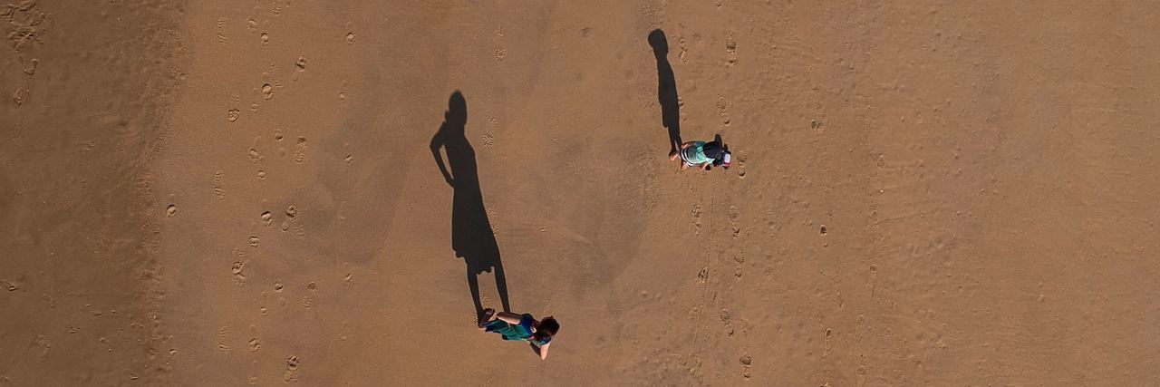 parent and child stand far apart from each other in the desert