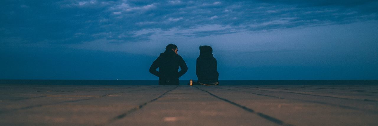5 Ways You Can Help a Friend Who Feels Suicidal two people sitting at the end of a dock at night