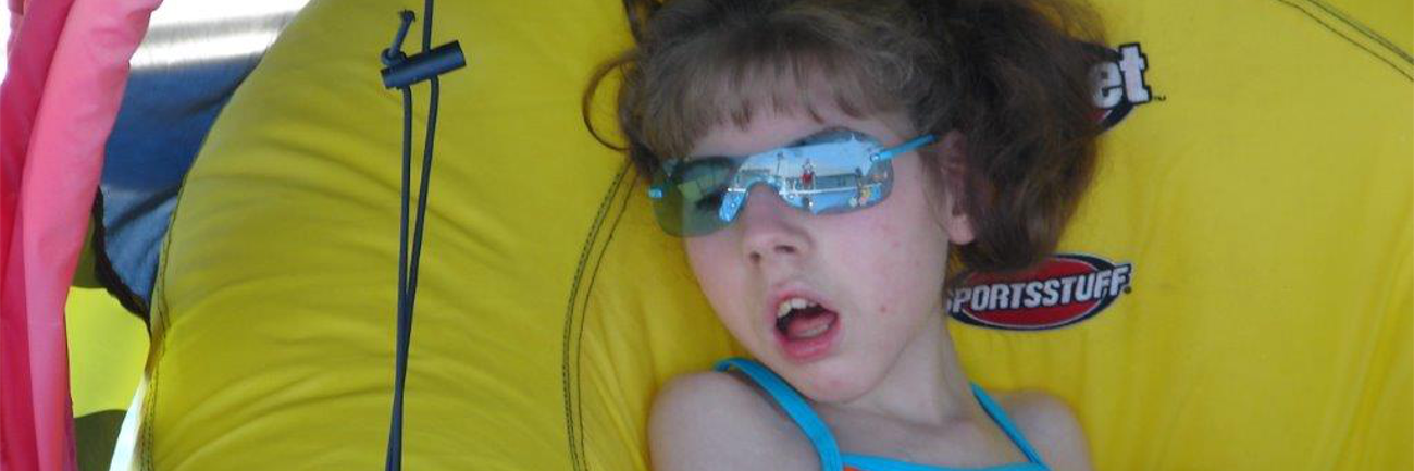 Grieving the Loss of a Child With a Disability Megan wearing a swimsuit inside a yellow inner-tube