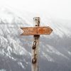post with an arrow pointing right in front of a snowy mountain