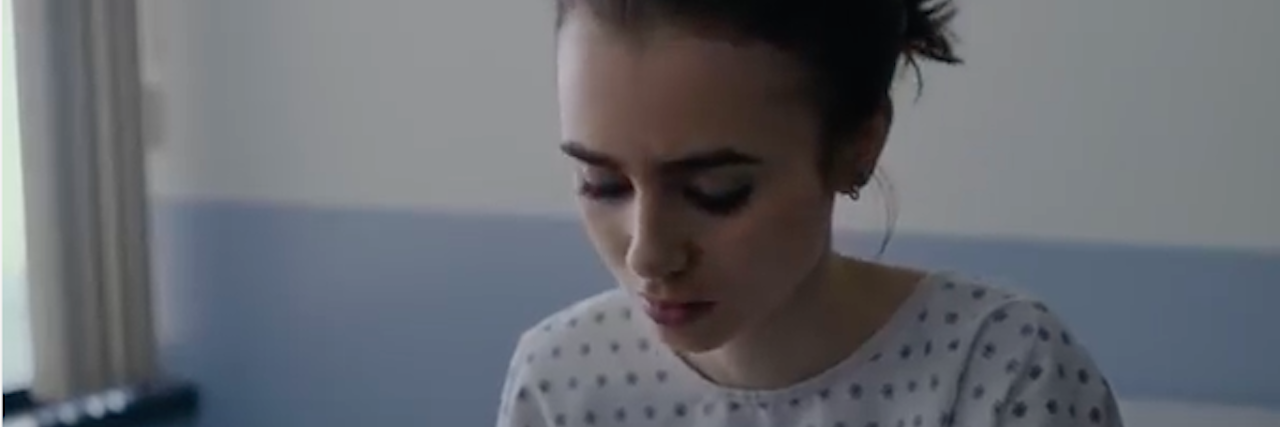 lily collins in hospital gown looking down from to the bone trailer
