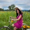Woman riding trike by flower field