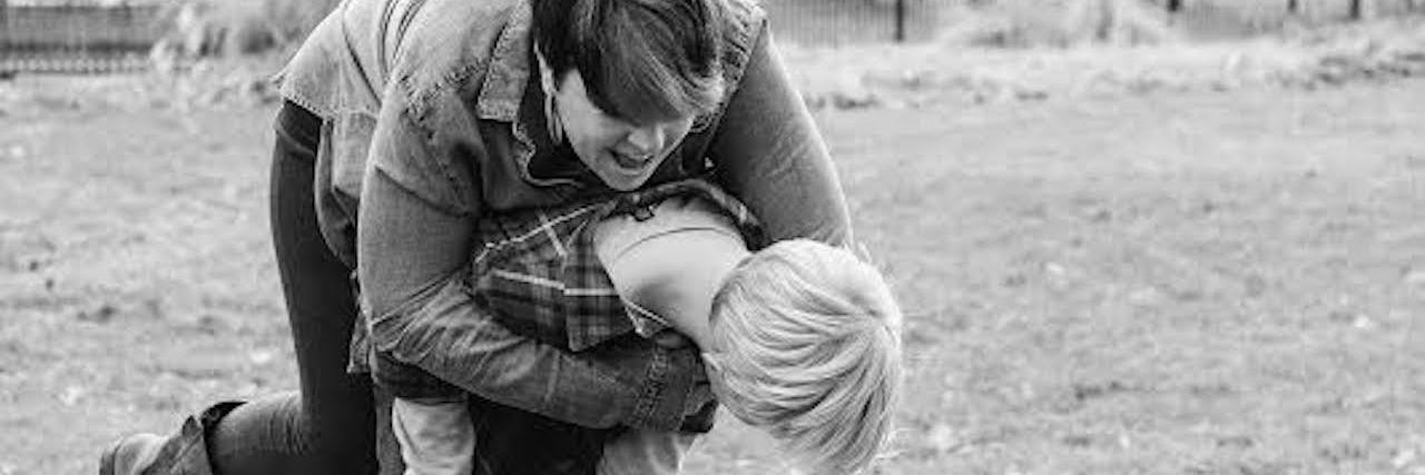 Being a Parent With Cerebral Palsy, Raising Kids to Be Independent black and white photo of a woman playing outside with her son