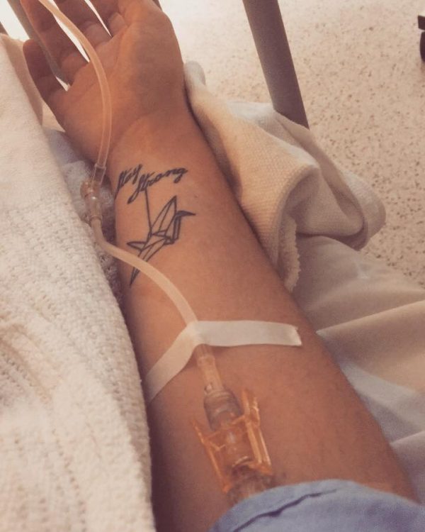 woman with tattoo that says 'stay strong' on her arm with an iv