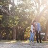 couple kissing outside in front of trees