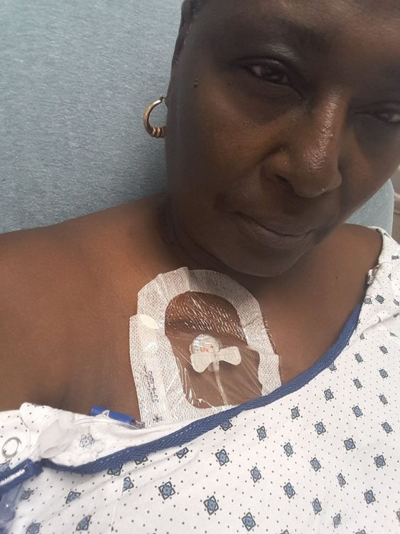 selfie of a woman in a hospital gown and IV in her chest