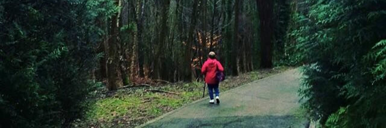 Coping With Brain Fog From Chronic Pain and Depression woman walking down a path in a foggy forest