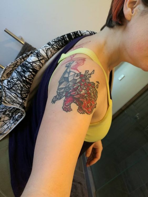woman with dinosaur tattoo on her shoulder
