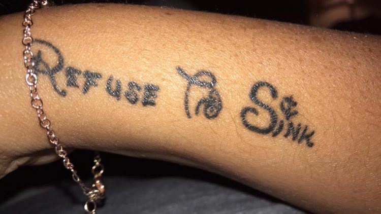 woman with tattoo on her arm that says 'refuse to sink'
