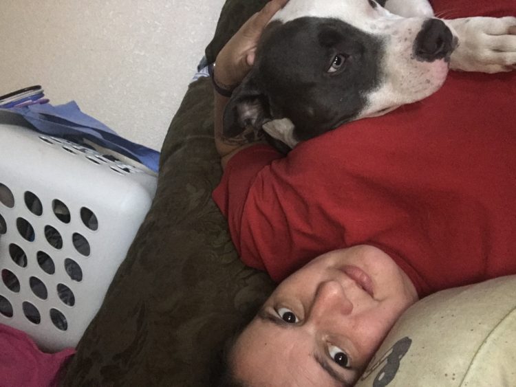 woman lying in bed with her dog