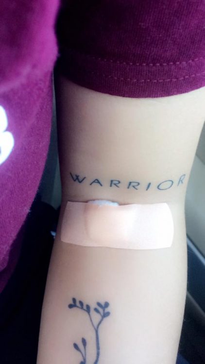 woman's warrior tattoo above her IV location in her arm