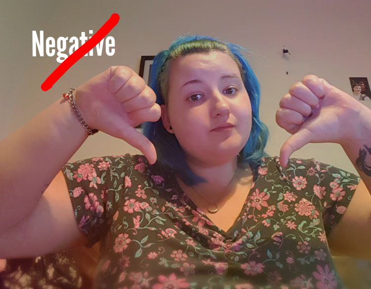 woman giving a thumbs down with the word 'negative' crossed out