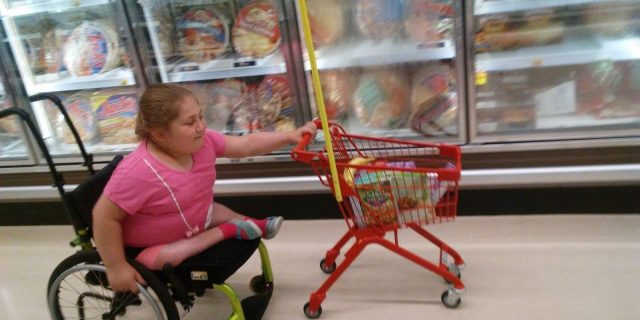 Pushing a Grocery Cart Was a Confidence-Booster for My Daughter With a Disability Namine pushing a shopping cart with one hand