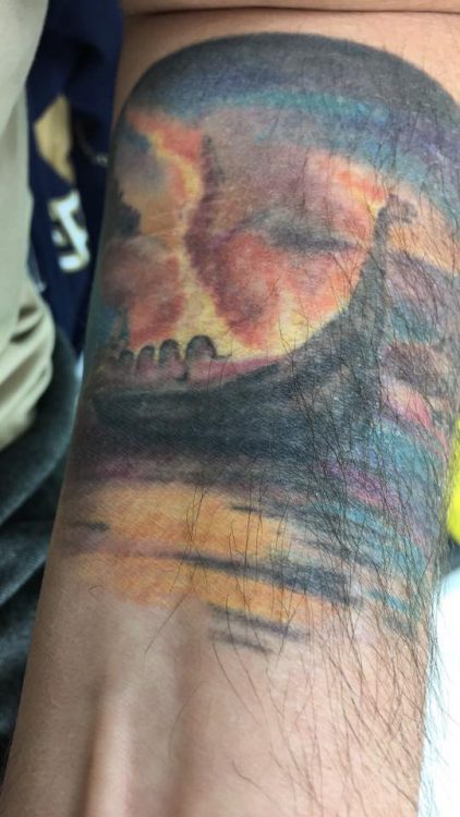 man with valhalla tattoo on his arm