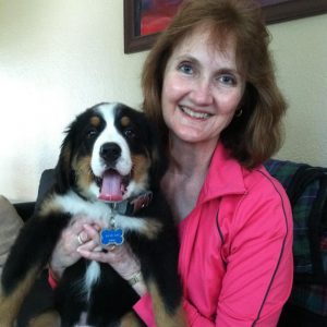 woman smiling and holding her dog