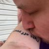 image of man kissing woman's arm with self-harm scars and tattoo