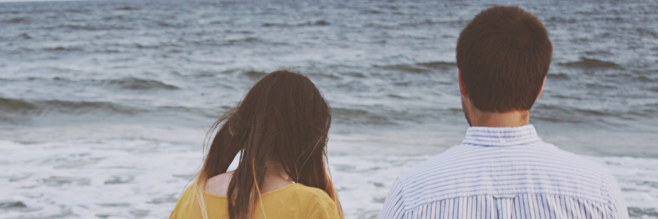 How Love Gets Me Through Life With Chronic Pain and Illness man and woman holding hands on the beach