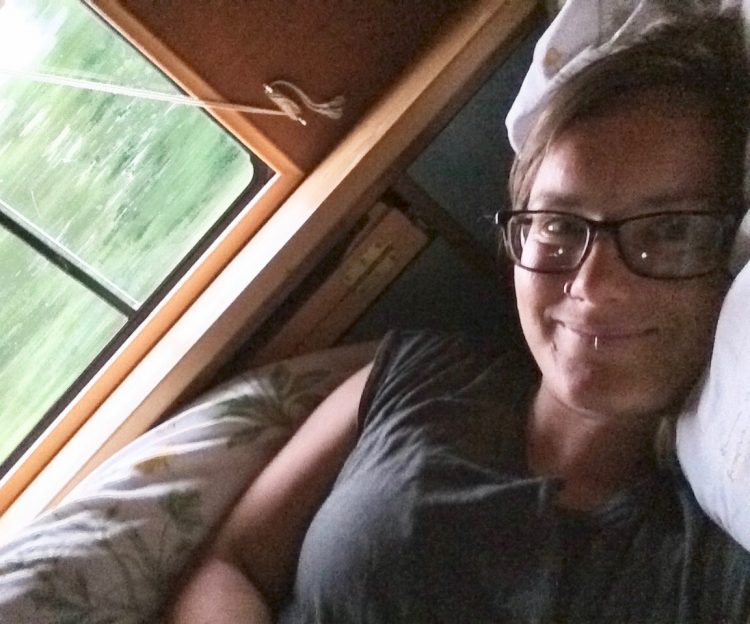 woman lying in bed resting inside her van