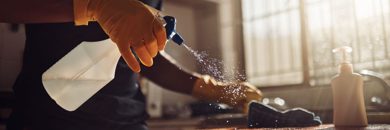 26 'Hacks' to Make Cleaning With a Chronic Illness Easier A person with rubber gloves cleaning a counter