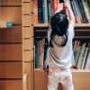 A child choosing books from the bookshelf