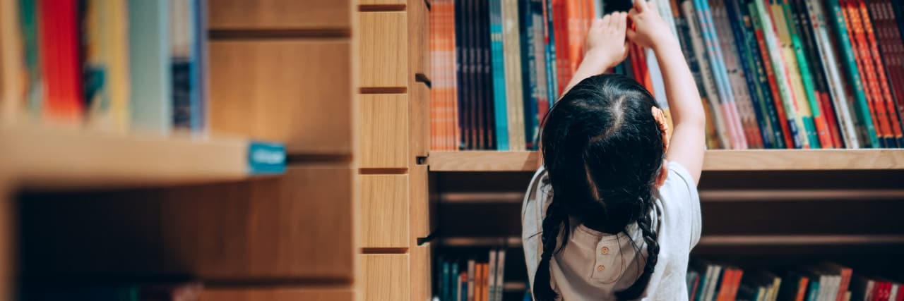 22 Signs You Grew Up With Fibromyalgia A child choosing books from the bookshelf
