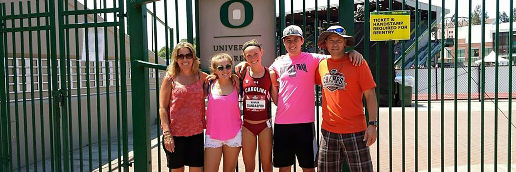 young woman with family in front of oregon university gates