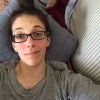 selfie of a woman lying on her couch and wearing glasses