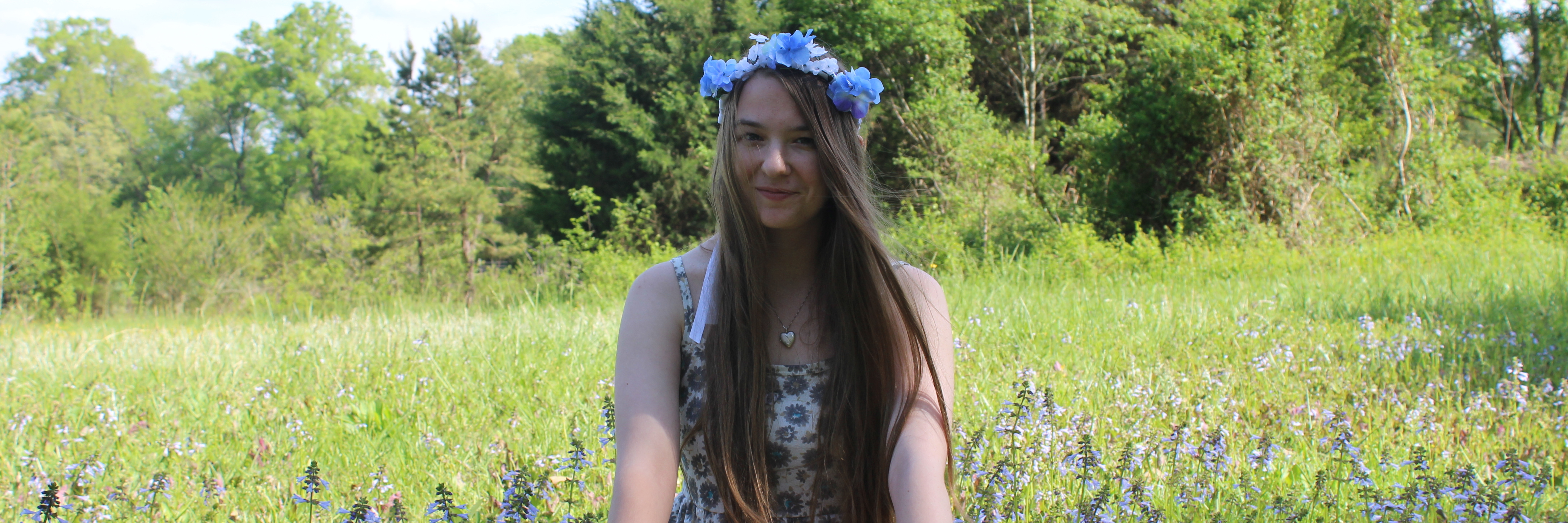 Finding Happiness in the Present Moment With Lyme Disease woman wearing flower crown and sitting cross-legged in a field