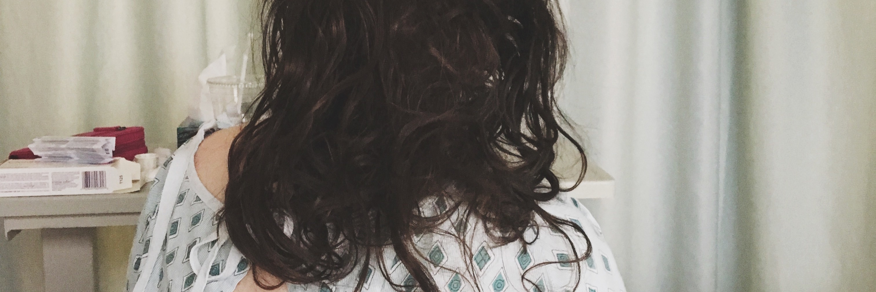 Why Doctors Need to Read Stories on The Mighty woman sitting in a hospital bed wearing a hospital gown