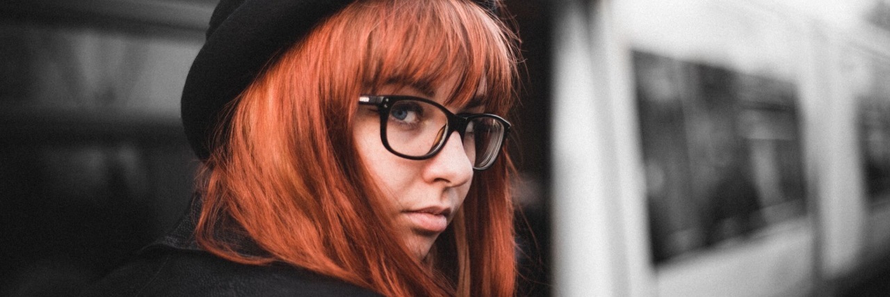 We Need More Awareness of Autism in Women Lauren Hooper, red-haired woman wearing a black cap. Subway car in background.