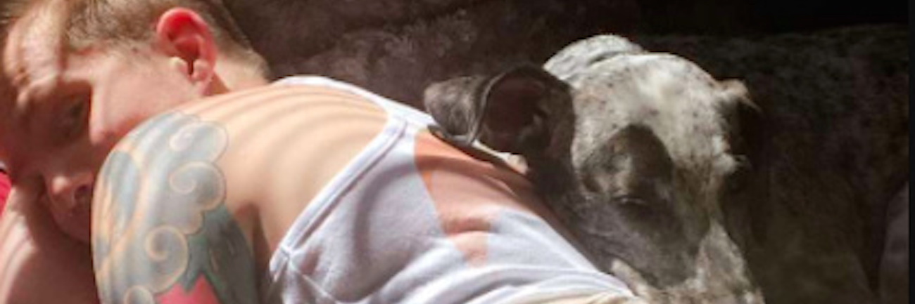 Talking About the Effects of My Chronic Pain and Breaking Down Shame The author lying in bed next to author's dog