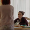 Ellen and her sister sit at a table while her mom stands