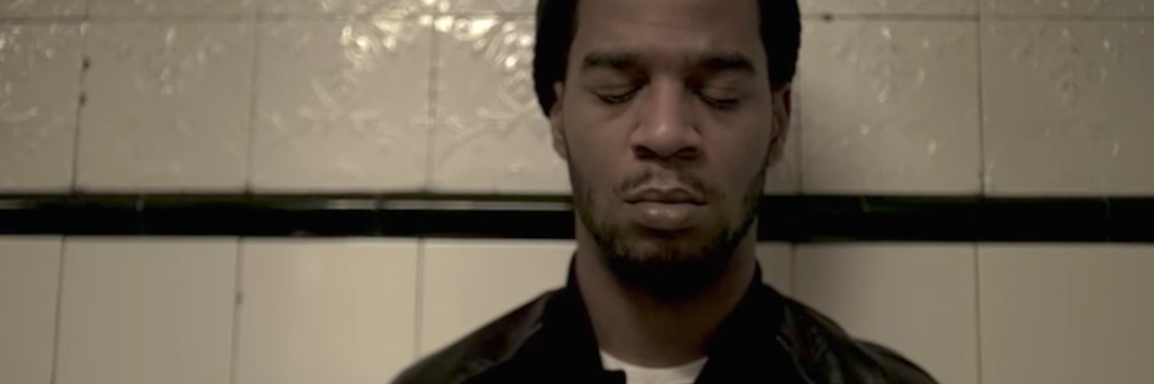 23 Songs That Have Helped People When They Were Suicidal Musician Kid Cudi sits with his eyes closed in a dimly lit room.