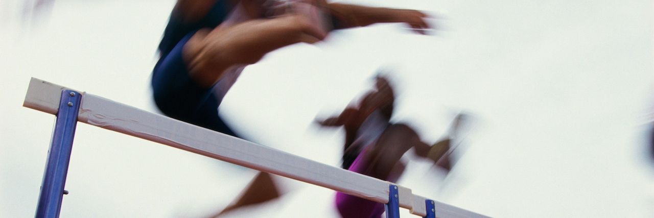 What It's Like Being a Sports Psychologist With Depression Woman going over hurdles