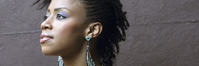 portrait of a woman with colorful earrings looking off into the distance