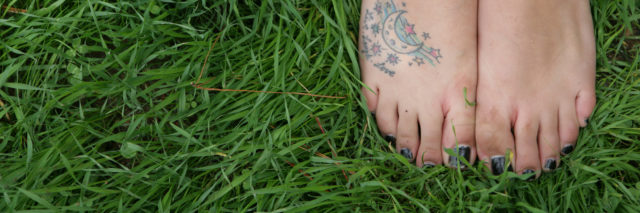 High angle view of woman's barefeet with tattoo.