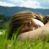 A woman laying down in grass