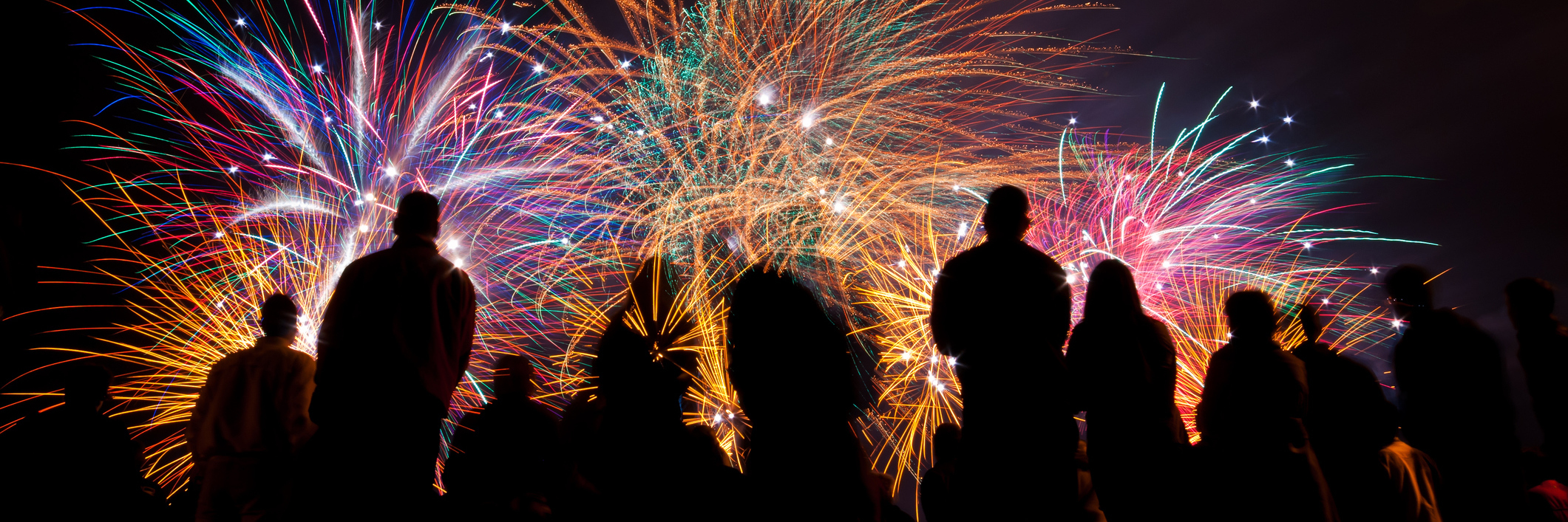 silhouettes of people watching fireworks