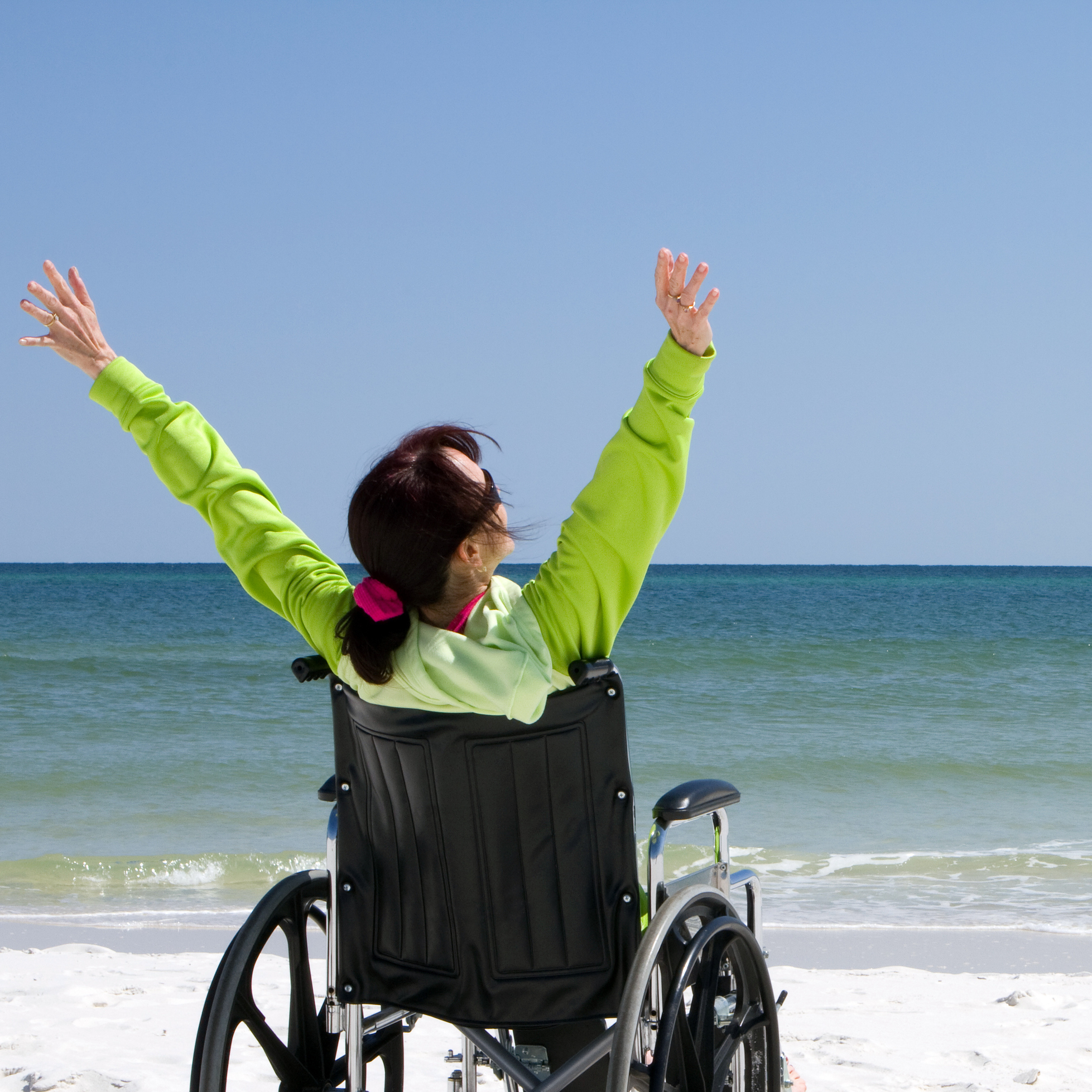 Woman in a wheelchair on the beach.