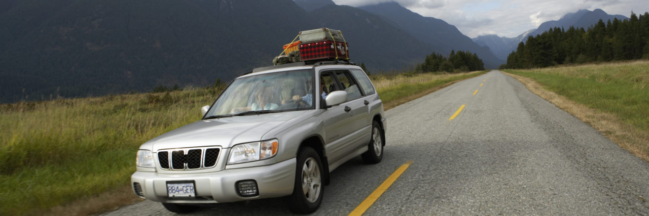 Tips for a Road Trip With Chronic Pain and Disabilities Car on a road trip with suitcases on roof.