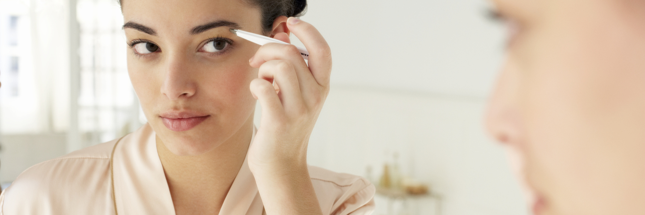 Using Makeup to Find Beauty in Yourself and Life With Chronic Illness woman applying makeup in the mirror