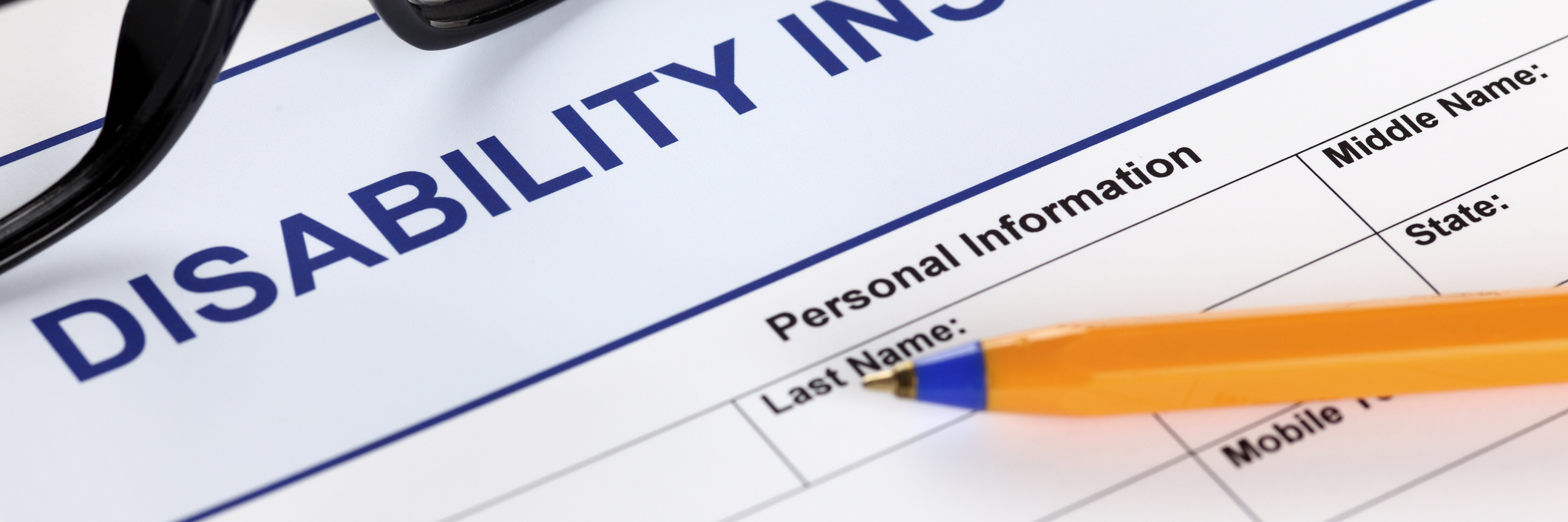 The Reality of Needing to Be on Disability Disability form with glasses and ballpoint pen.