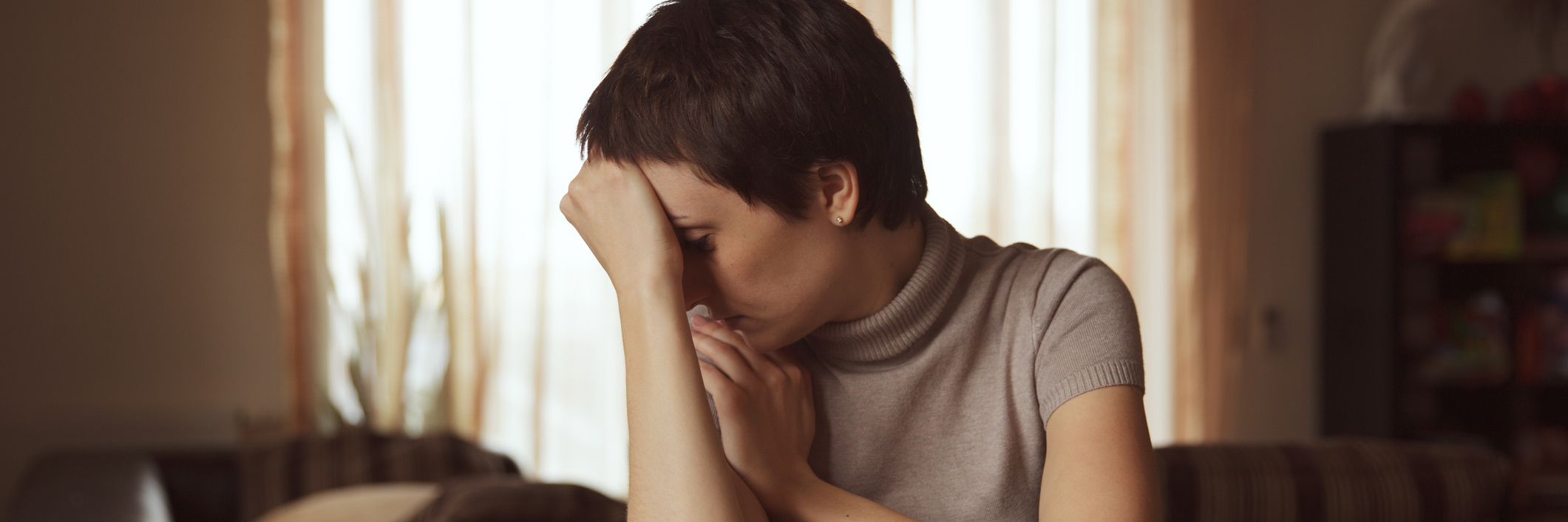 When 'What If' Thoughts Take Over Every Part of Your Day sad woman sitting at wooden table