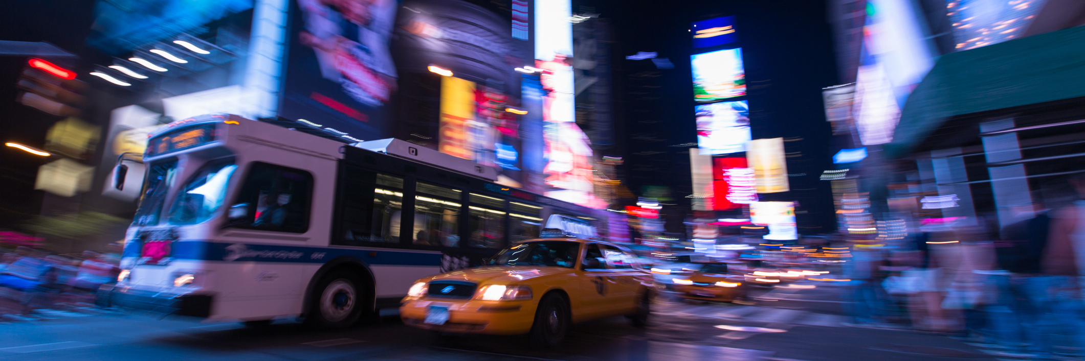 Technology and Transportation Options as a Blind Person A long exposure night shot of a bus and a yellow cab driving through Times Square, NYC.