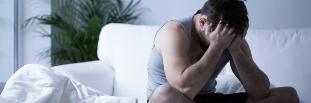 young man sitting on bed depression
